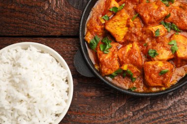 Tavuklu tikka masala. Pirinç ve maydanozlu. Tahta masada.