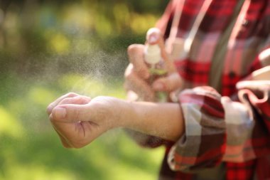 Parkta kene püskürtücü sıkan kadın, yakın plan.