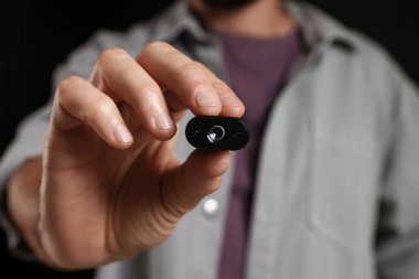 Siyah arka planda gizli casus kamerası olan adam, yakın plan.