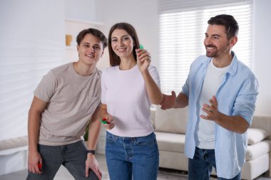 Kadın ve arkadaşları evde dart oynuyorlar.