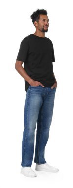 Beyaz arka planda şık kot giyen mutlu bir adam.