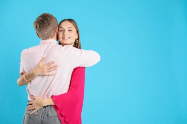 Açık mavi arka planda kucaklaşan sevimli bir çift, mesaj için yer var. Romantik randevu