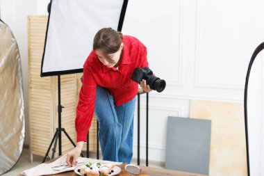 Stüdyoda ayçörekleriyle kompozisyon hazırlayan bir kadın. Mesaj için yer var. Profesyonel yemek fotoğrafçılığı.