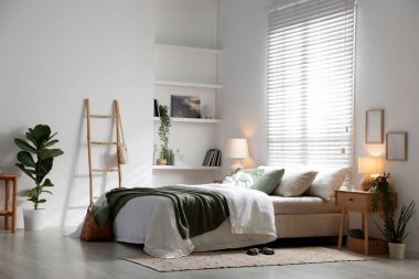 Büyük yataklı, yastıklı, çiçekli ve lambalı şık bir yatak odası. İç tasarım