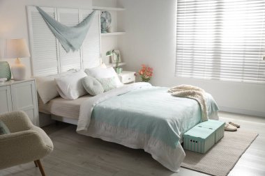 Büyük yataklı, yastıklı ve lambalı şık bir yatak odası. İç tasarım