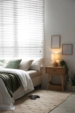 Büyük yataklı, yastıklı, çiçekli ve lambalı şık bir yatak odası. İç tasarım