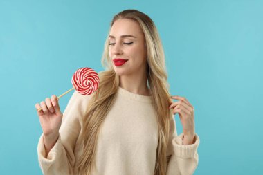 Noel kutlaması. Açık mavi arka planda lolipopu olan kadın