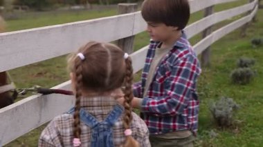 At destekli terapi. Çayırda güzel midillisi olan sevimli çocuklar. Sevimli evcil hayvan