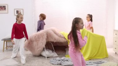 Evde pijamalı şirin çocuklar oynuyor.