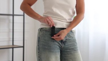 Cebinde gizli kamera olan genç bir kadın. Kapalı mekanda, yakın plan. Kamera ileri gidiyor