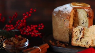 Noel yemeği. Lezzetli Panettone pastası ve ahşap masada şenlikli bir dekor, yakın plan. Kamera sağa hareket ediyor