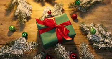 Noel hediyeli kadın, köknar ağacı dalları ve ahşap masa süsleri, yakın plan.