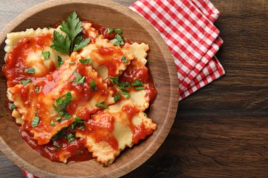 Domates soslu lezzetli ravioli ve ahşap masada maydanoz.