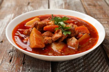 Tahta masadaki kasede nefis pişirilmiş güveç. Yakın plan.