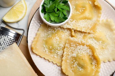 Beyaz mermer masada servis edilen peynirli lezzetli ravioli.