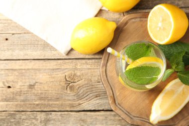 Limonla ferahlatıcı su ve ahşap masa üzerinde nane şekeri, düz uzanmış. Metin için boşluk
