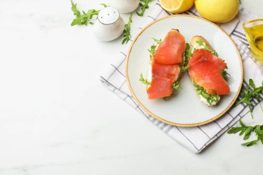 Beyaz mermer masada servis edilen somon ve roka ile nefis bruschetalar. Metin için boşluk