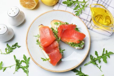 Beyaz mermer masada servis edilen somon ve roka ile nefis bruschetalar.
