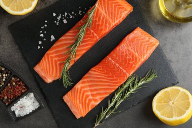 Somon fileto parçaları ve baharatlar gri masada, düz yatıyordu.