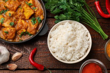 Tavuklu tikka masala, pirinç ve baharatlar ahşap masada, düz yerde.