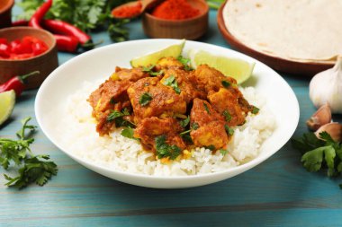 Pirinç, maydanoz, kireç ve baharatlı leziz tavuk tikka masala açık mavi ahşap masa, yakın plan