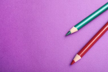 Mor arka planda farklı göz kalemleri, üst manzara. Metin için boşluk