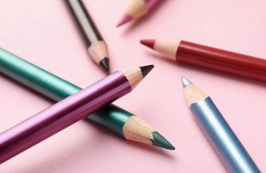 Pembe arka planda parlak göz kalemleri, yakın plan.