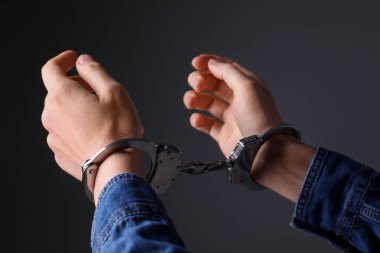 Gri arka planda metal kelepçeli kadın, yakın plan.