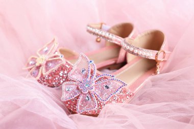 Bir çift şık çocuk ayakkabısı tül kumaş üzerinde, yakın plan.