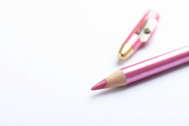 Beyaz arka planda kapaklı pembe göz kalemi, yakın plan. Metin için boşluk