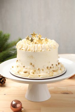 Hafif ahşap masada Noel dekoru olan lezzetli bir pasta, yakın plan.