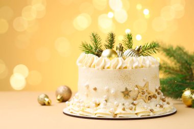 Bej arka planda Noel dekoru olan enfes bir pasta bulanık ışıklara karşı, mesaj için yer. Bokeh etkisi