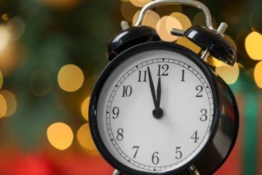 Yeni yıl tebrik kartı. Alarm saati renk arkaplanına karşı bulanık ışıklarla, metin için boşluk ile yakın plan. Bokeh etkisi