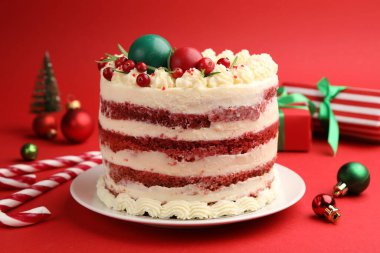 Noel dekoru ve kırmızı arka planda böğürtlenli leziz sünger kek.