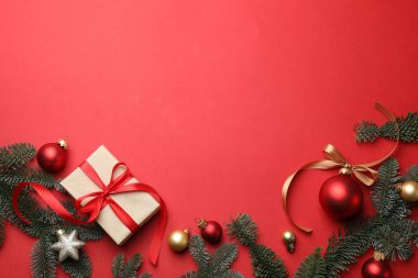 Firavun ağacı dalları, hediye ve kırmızı arka planda Noel süsü, düz bir zemin. Metin için boşluk