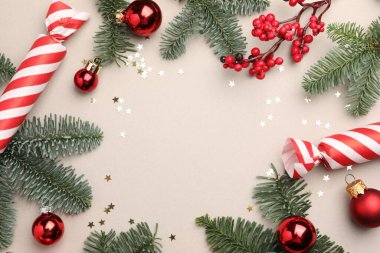 Köknar ağacı dalları, şekerler ve arka planda Noel süslemeleri, düz bir zemin. Metin için boşluk