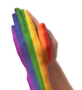 Beyaz arka planda ellerini gösteren adam, yakın plan. Kollarından biri LGBT bayrağı renginde
