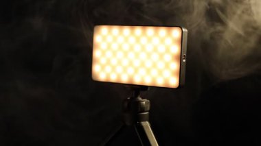 Üç ayaklı lamba üzerinde parlayan LED lamba dumanlı, yakın plan