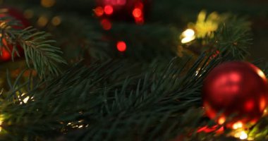 Işıkları ve süsleri olan güzel bir Noel ağacı, yakın plan. Kamera sağa hareket ediyor