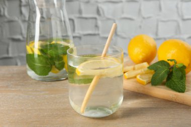 Limonlu ve nane şekerli suyu ahşap masaya serpiştiriyorum. Yakın plan.