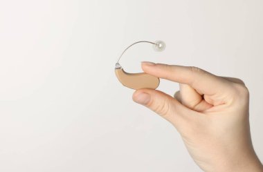 Hafif arka planda işitme cihazı olan kadın, yakın plan. Metin için boşluk