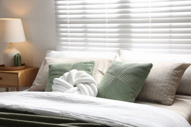 Büyük yataklı, yastıklı ve lambalı şık bir yatak odası. İç tasarım