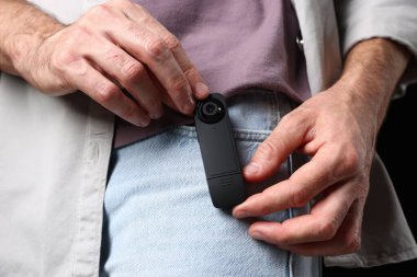 Cebinde gizli kamera olan bir adam, yakın plan.