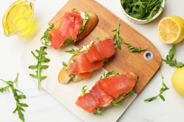 Beyaz mermer masada servis edilen somon ve roka ile nefis bruschetalar.