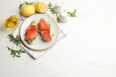 Beyaz mermer masada servis edilen somon ve roka ile nefis bruschetalar. Metin için boşluk