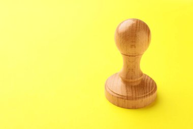 Sarı arka planda bir tahta damga, yakın plan. Metin için boşluk