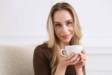 Kadın evde kakao içmekten zevk alıyor.