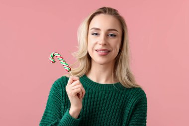 Noel kutlaması. Pembe arka planda baston şekerli kadın