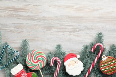 Güzel Noel ağacı dalları, baston şekerler ve hafif ahşap arka planda zencefilli kurabiyeler, düz uzanma. Metin için boşluk