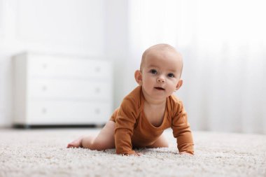 Evde yerde yatan şirin bir bebeğin portresi.